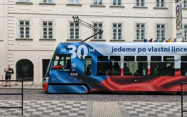 A modern Prague tram sports an advertising wrap.